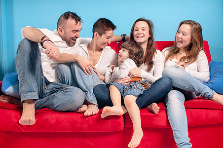 幸福的家庭在沙发上女士拥抱儿子快乐女性父母母亲白色女儿感情图片