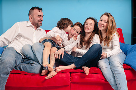 幸福的家庭在沙发上乐趣女士母亲女孩男生拥抱父母白色孩子们女儿图片