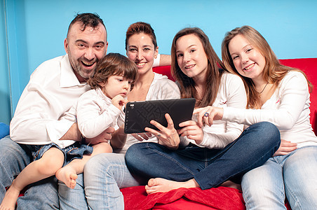 在沙发上用平板电脑快乐乐趣女士孩子们女儿父母白色女性男生药片图片