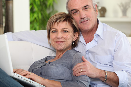 夫妇在家里用笔记本电脑恋人男人技术白色家庭男性夫妻女士微笑工作图片
