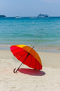 沙滩上的橙色雨伞旅行天空娱乐海洋热带时间橙子比基尼闲暇蓝色图片