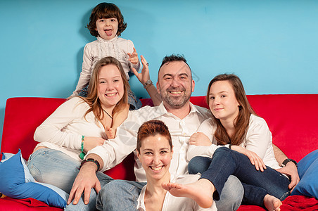 幸福的家庭在沙发上父亲男生快乐牛仔裤白色女儿拥抱父母母亲女士图片