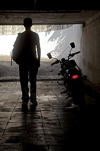 男人在一辆摩托车附近的黑暗隧道里图片