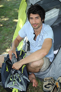男子坐在帐篷入口处图片