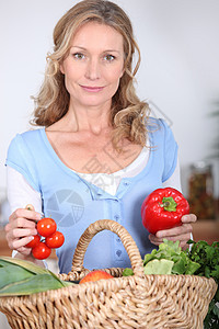 怀着胡椒和西红柿的妻子女性食物蔬菜女士幸福头发篮子厨房福利金发图片