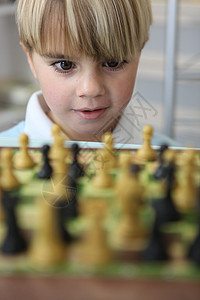 玩象棋的小男孩男生沉思娱乐乐趣智慧典当木板桌子婴儿挑战图片