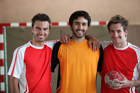 3名青年男子在室内用手球背景图片