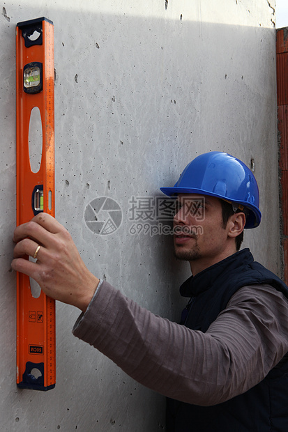 从事水平测量的手工艺工人男人乐器木头蓝色帽子构造头盔房子建造工匠图片