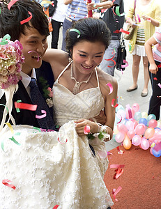 一对年轻夫妇在结婚当天玫瑰新娘接待家庭花束快乐浪漫男性人像婚姻图片