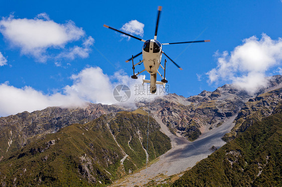 救援直升机飞越山地荒野上空图片