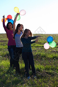 三名美丽的年轻女子 带着气球进入田野对抗自由青少年太阳女孩们假期阳光闲暇微笑女性团队图片