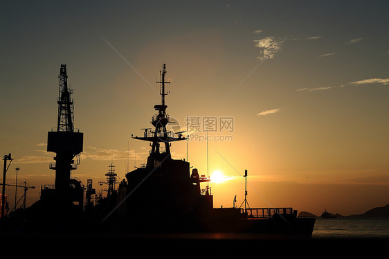 日落时停靠在码头的起重机橙子螺旋桨尾巴货物避风港检修雕刻船运后勤船厂图片