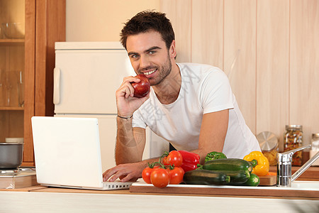 男用笔记本电脑和蔬菜在厨房的男人图片
