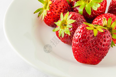 白盘上的草莓浆果红色甜点宏观白色绿色食物水果图片