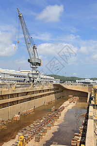 Crane靠近船坞一个覆盖的干燥码头商业工程货运造船船运船厂工业天空港口全景图片