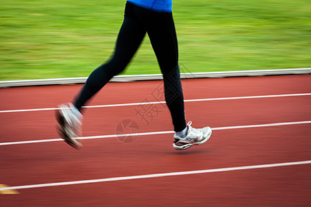 年轻妇女在赛场和田径体育场跑步快乐蓝色竞赛火车女士闲暇活动训练女性竞技图片