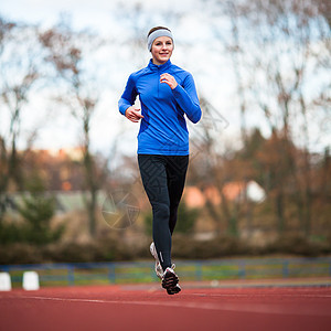 年轻妇女在赛场和田径体育场跑步运动活动活力训练女性赛跑者肌肉闲暇娱乐运动员图片