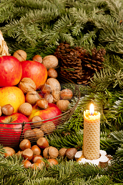 圣诞节还带着蜡烛过着圣诞内饰榛子水果静物锥体传统核桃符号食物坚果图片