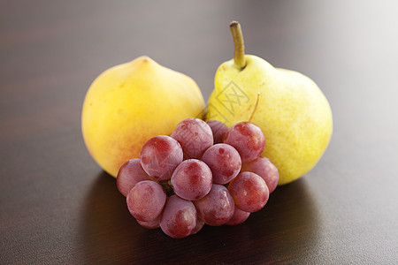 桃子 梨子和葡萄 放在木制桌子上图片