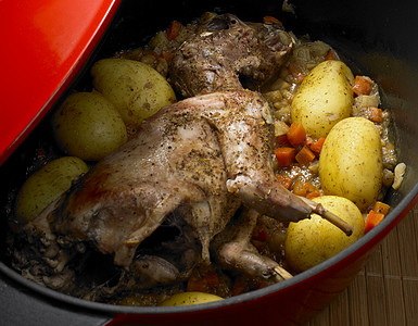 从一个锅子中打出带边盘的兔子熟食熟菜食品土豆内饰营养盘子美食兔肉食物图片