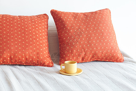 床铺上有两个枕头 毯子上还有一杯茶来源早餐杯子窗户卧室软垫木头家具床单寝具图片