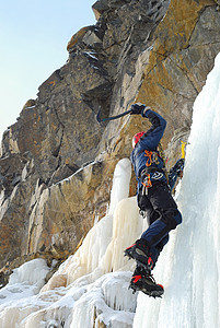 年轻人 攀登冰河是一条有吸引力的路线运动登山者瀑布锤子首脑冰爪头盔远足者男人工具图片