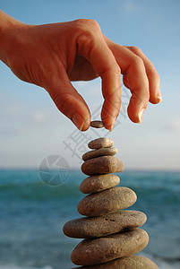 在石头沙滩上的石塔岩石沉思团体平衡想像力进步蓝色天空阳光卵石图片