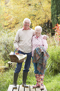 秋天林地边上带烧烤篮子的老年夫妇户外女性男人树叶妻子亲热农村木头叶子感情女士图片
