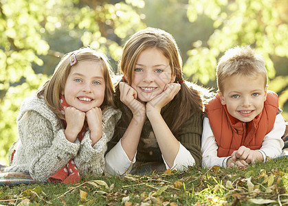 3组儿童在秋季风景中挤进户外公园拥抱姐姐女孩三个人孩子们说谎花园笑声男生图片