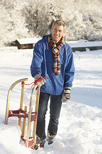 中年男子站在雪地景观控股悬崖男性场地天气下雪微笑针织品围巾场景寒冷笑声图片