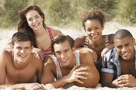 朋友团体在海滩与足球一起放松轻松五个人运动青少年水平行动朋友们享受夫妻女性男性图片