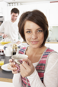 准备早餐的年轻夫妇在现代厨房烹饪杯子建筑学两个人女士成人设计师男性柜台微笑食物图片