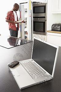 现代厨房用笔记本电脑修理厨房的草纸长度办公冰箱电冰箱男性电话冲浪成人居家细胞图片