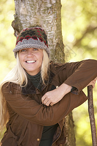 秋季木林园街外行走的年轻女性青年公园帽子微笑服装树木休闲拐杖林地农村场地图片