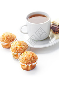 巧克力 茶叶和松饼 在白色上隔绝桌子飞碟牛奶小吃蛋糕甜点杯子生活文化糕点图片