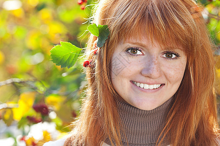 一位美丽的年轻红发女青年的肖像微笑叶子女孩乐趣金子地面成人天气学生青少年图片