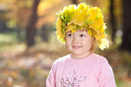 美丽的小女孩 在秋前秋叶的青树叶花圈中童年微笑叶子快乐黄色公园森林女孩乐趣压痛图片