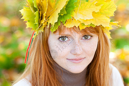 一位美丽的年轻红发女青年 在花圈的肖像学生成人天气女性微笑叶子乐趣森林女孩喜悦图片