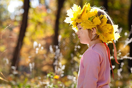 美丽的小女孩 在秋前秋叶的青树叶花圈中微笑孩子压痛女孩黄色公园森林童年女性快乐图片