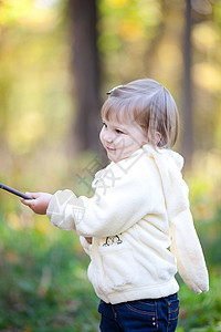 秋天森林上有根棍子的美丽的小女孩叶子孩子季节乐趣公园童年红色幸福女性快乐图片