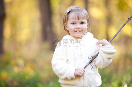 秋天森林上有根棍子的美丽的小女孩幸福微笑红色叶子童年女孩橙子乐趣孩子黄色图片