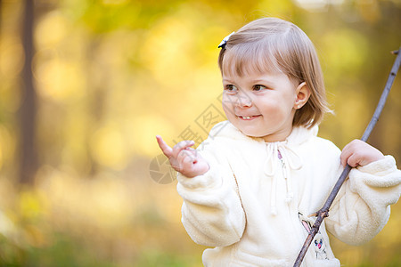 秋天森林上有根棍子的美丽的小女孩橙子乐趣叶子公园女孩孩子幸福快乐红色微笑图片