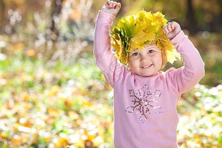 美丽的小女孩 在秋前秋叶的青树叶花圈中女儿压痛公园乐趣童年叶子幸福女性森林孩子图片