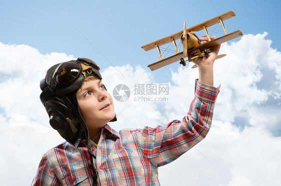 戴头盔飞行员的男孩玩玩具飞机木头童年翅膀旅行蓝色男生空气勇气帽子男性图片