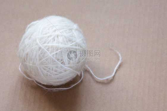 纸板背景上的白羊毛线球羊驼材料绳索旋转手工细绳纤维白色褐色加工图片