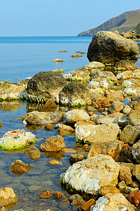 海岸的巨石海景场景边缘海洋阳光岩石石头潮汐天空海岸线图片