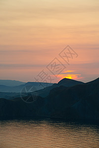 山岳和大海之间多彩的衰落悬崖日落异国旅行戏剧性海湾情调天空山脉海岸线图片