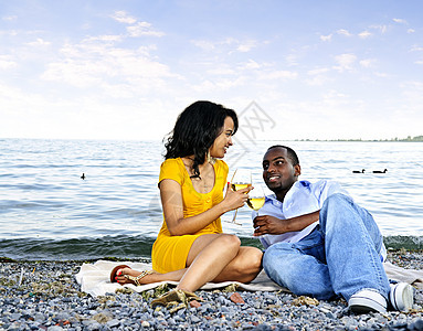 幸福的情侣在海滩上喝酒饮料海洋玻璃女士野餐男人海岸支撑微笑眼镜图片