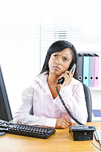 关心此事的黑人女商务人士在办公桌上打电话沟通女孩办公室桌子听筒人士秘书成人电话桌面图片