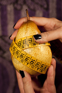 带有测量胶带的梨子概念红色水果磁带食欲重量身体贪食症指甲女孩图片